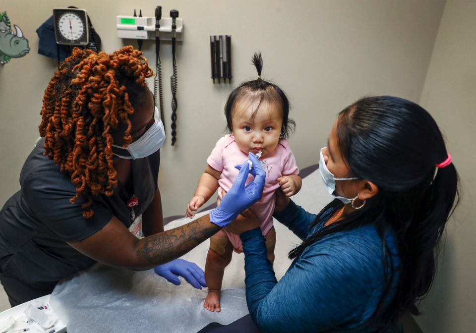 <strong>Shot nurse Tiqua Eaton (left) gives immunizations to Milinda Francisco Andres, 6 months, as her mother Petrona Andres (right) helps at Christ Community Health Services on Tuesday, Sept. 21, 2021. Between 2019 and 2020, the number of non-COVID vaccines given by the Shelby County Health Department dropped nearly 60%.</strong> (Mark Weber/The Daily Memphian)