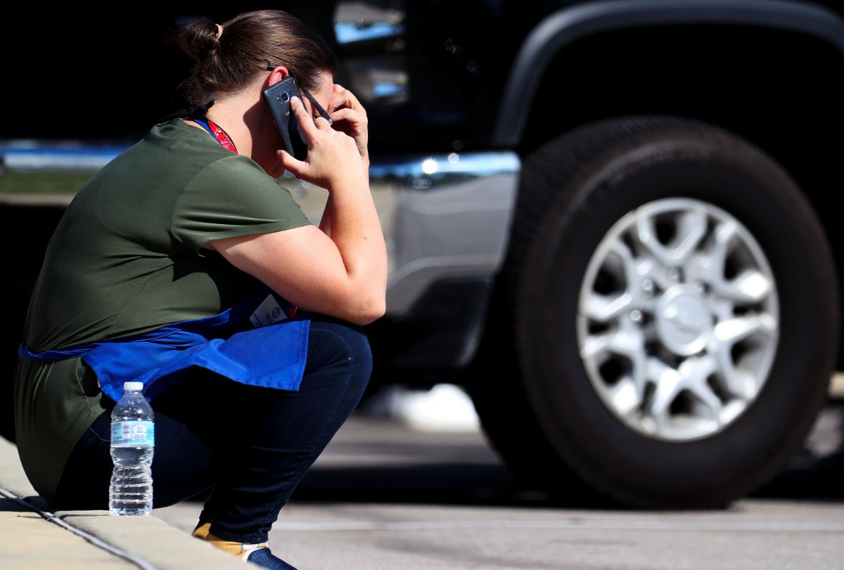 <strong>A survivor of the mass shooting at a Kroger in Collierville makes a call at the crime scene on Sept. 23, 2021.</strong> (Patrick Lantrip/Daily Memphian)