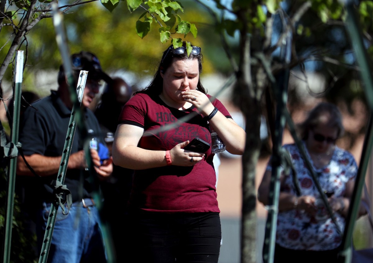 <strong>A survivor of the mass shooting at a Kroger in Collierville checks her phone at the crime scene on Sept. 23, 2021.</strong> (Patrick Lantrip/Daily Memphian)
