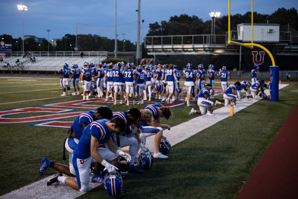 <strong>MUS players kneel before the start of Friday night&rsquo;s game against Ridgeway at Memphis University School.</strong>&nbsp;(Brad Vest/Daily Memphian)