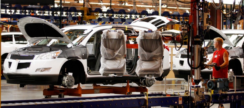 <strong>An assembly line worker uses a large robotic machine to install front seats in a 2009 Chevrolet Traverse at the GM Spring Hill Manufacturing Plant in 2008.</strong> (AP file Photo/Bill Waugh)