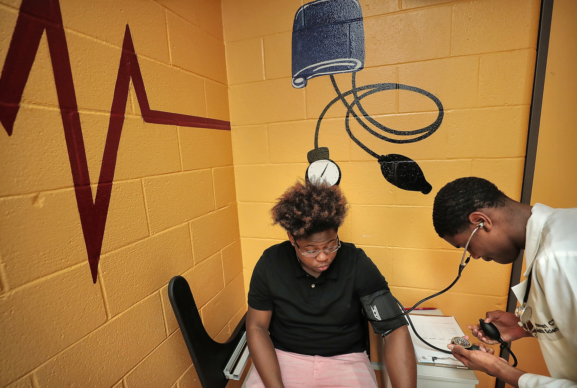 <strong>Kendrick Atkins (left) acts as the guinea pig for AJ Henderson, who is learning how to take&nbsp;blood pressure during health sciences class at the Trezevant Career and Technology Center. In conjunction with his recently announced&nbsp;proposal to expand access to vocational and technical training for high school students,&nbsp;Gov. Bill Lee's&nbsp;Future Workforce Initiative&nbsp;would launch new STEM-focused career and technical education programs in Tennessee's middle schools.&nbsp;</strong>(Jim Weber/Daily Memphian)
