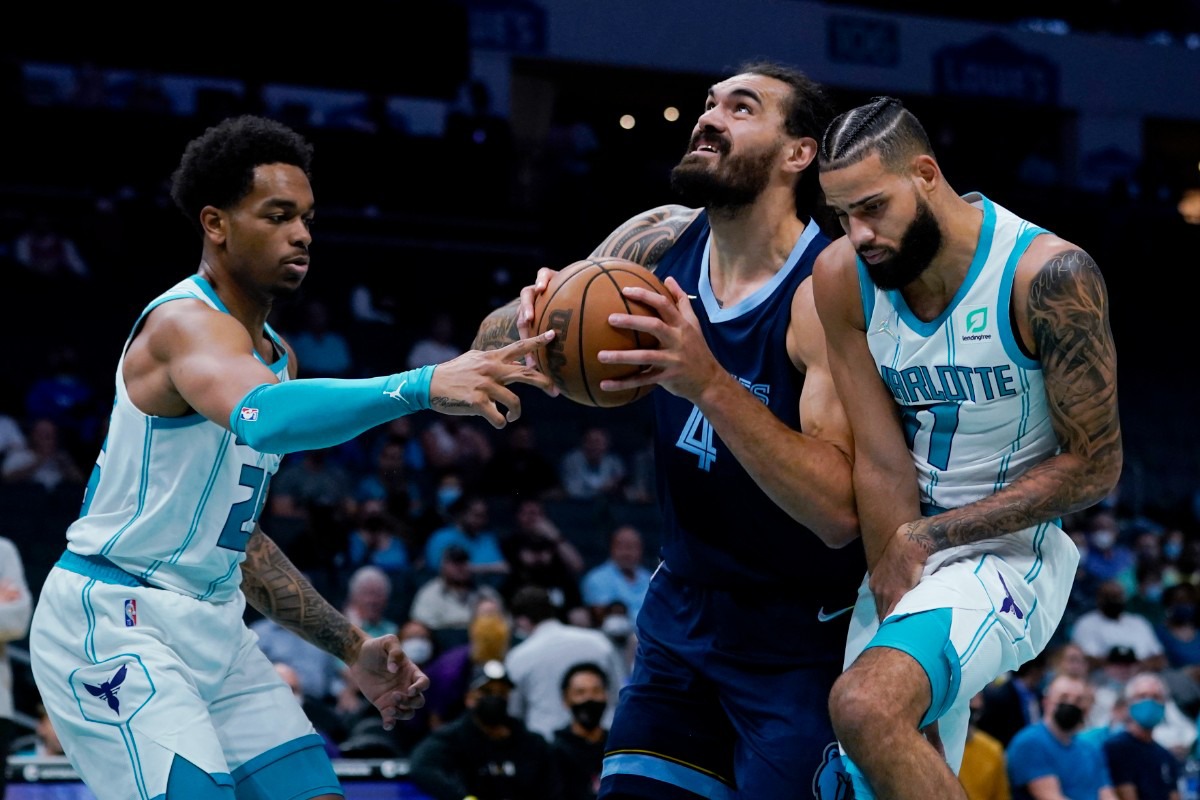 <strong>Memphis Grizzlies' Steven Adams drives to the basket between Charlotte forwards P.J. Washington, left, and Cody Martin&nbsp; on Oct. 7, 2021, in Charlotte, North Carolina.</strong> (Chris Carlson/AP)