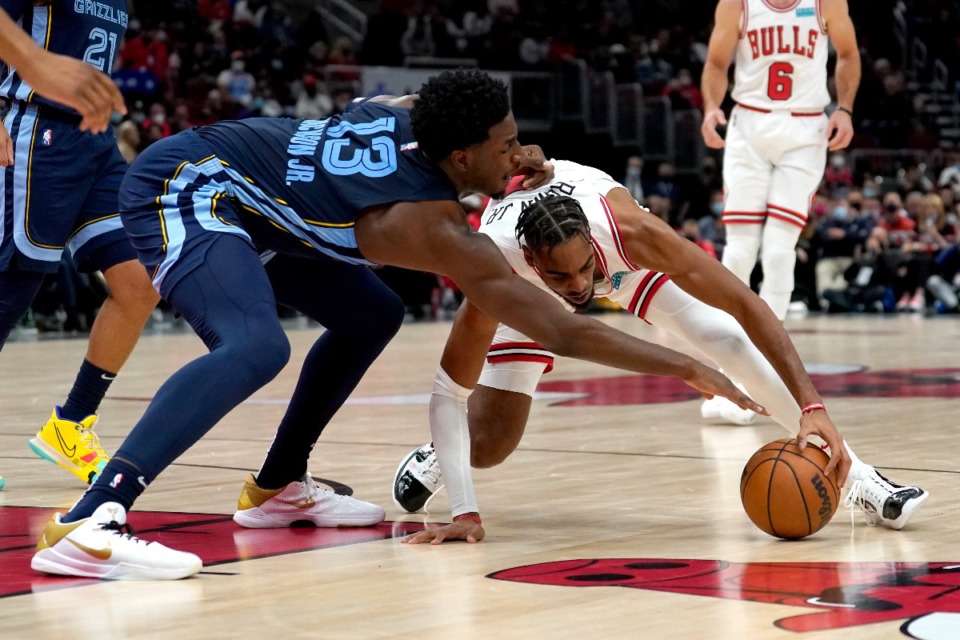 <strong>Jaren Jackson Jr. (13) and Chicago&rsquo;s Troy Brown Jr. vie for a loose ball&nbsp;on Oct. 15 in Chicago.</strong> (Charles Rex Arbogast/AP)
