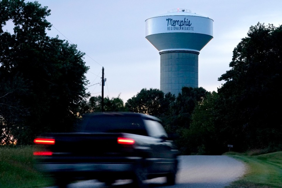 <strong>A truck drives down a rural road near a water tower marking the location of the Memphis Regional Megasite on Sept. 24, 2021, in Stanton. Ford Motor Co. and SK Innovation of South Korea plan to build three new electric-vehicle battery factories and an auto assembly plant by 2025 in Tennessee and Kentucky. The industrial site in Stanton will be the location for a factory to produce electric F-Series pickups and a battery factory.</strong> (AP Photo/Mark Humphrey)