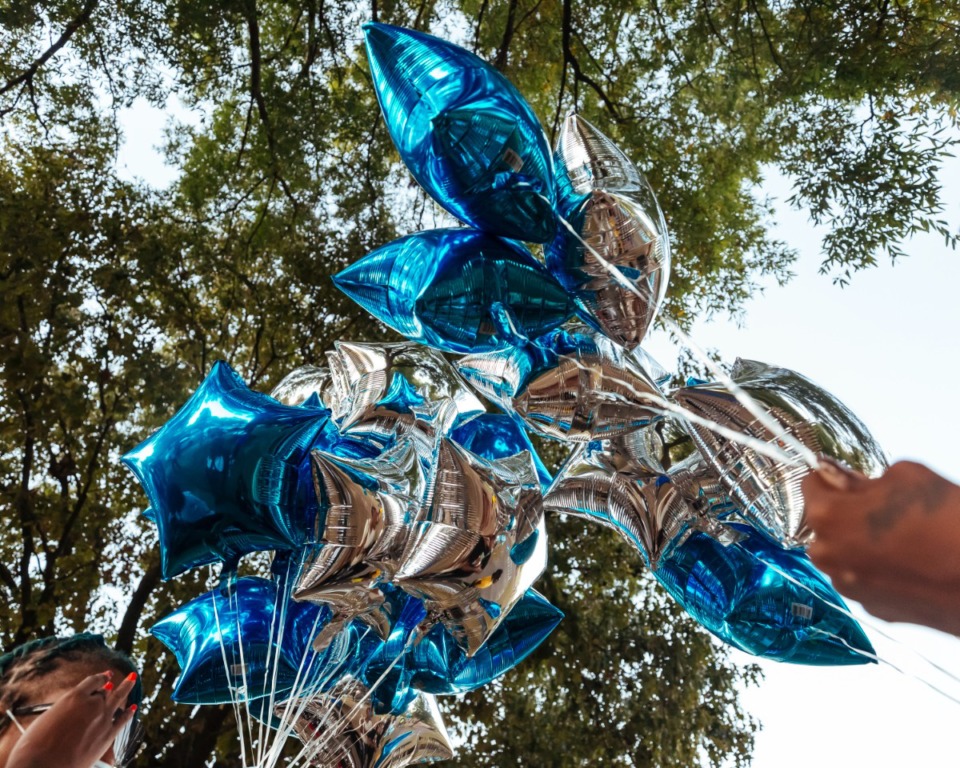 <strong>Mourners prepare balloons in the favorite football colors of slain USPS employee Demetria Dortch during her vigil at Lewis-Davis Park in Orange Mound&nbsp;on Oct. 20, 2021.</strong> (Ziggy Mack/Special to The Daily Memphian)
