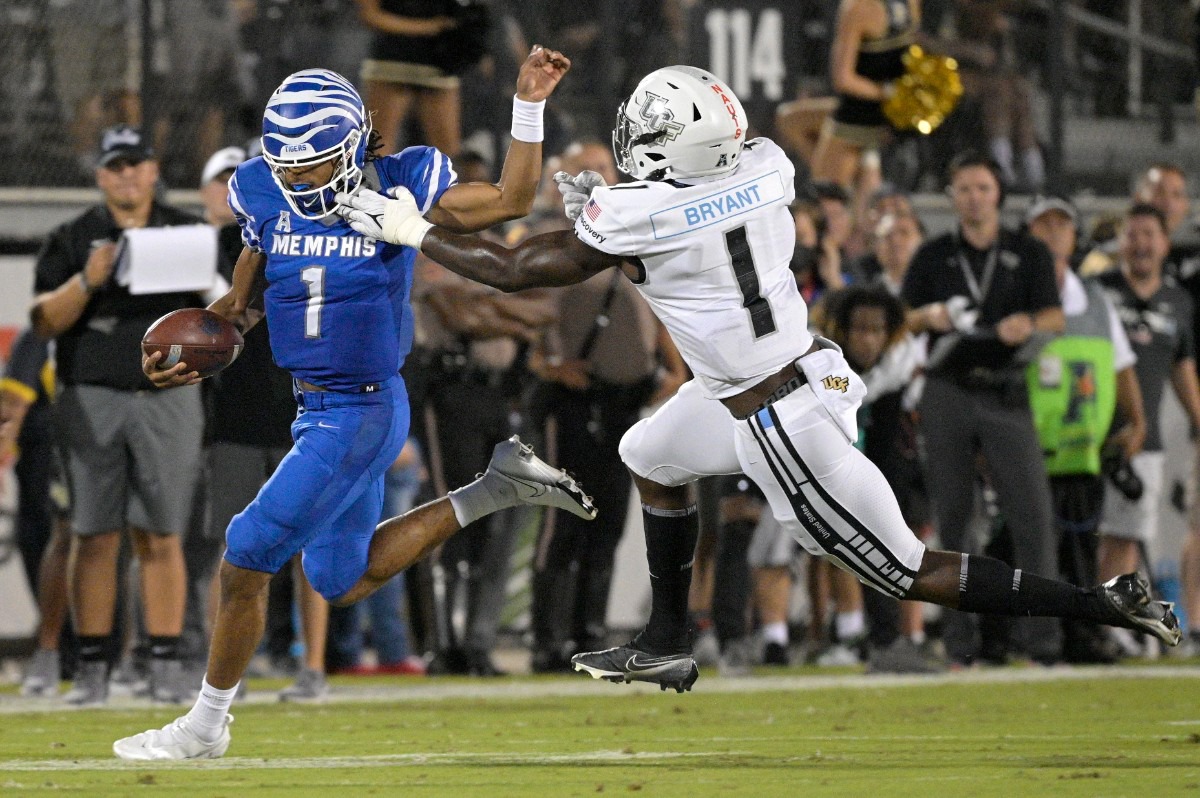 <strong>Memphis quarterback Peter Parrish, left, scrambles for yardage in front of Central Florida defensive lineman Big Kat Bryant (1) on Oct. 22, 2021, in Orlando, Florida.</strong> (Phelan M. Ebenhack/Orlando Sentinel via AP)