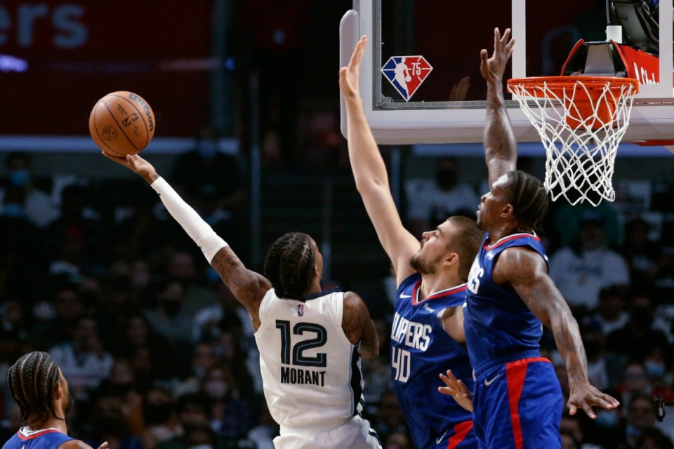 <strong>Memphis Grizzlies guard Ja Morant (12) shoots under pressure from Los Angeles Clippers center Ivica Zubac (40) and guard Eric Bledsoe (12) during the first half of an NBA basketball game Saturday, Oct. 23, 2021, in Los Angeles.</strong> (AP Photo/Ringo H.W. Chiu)