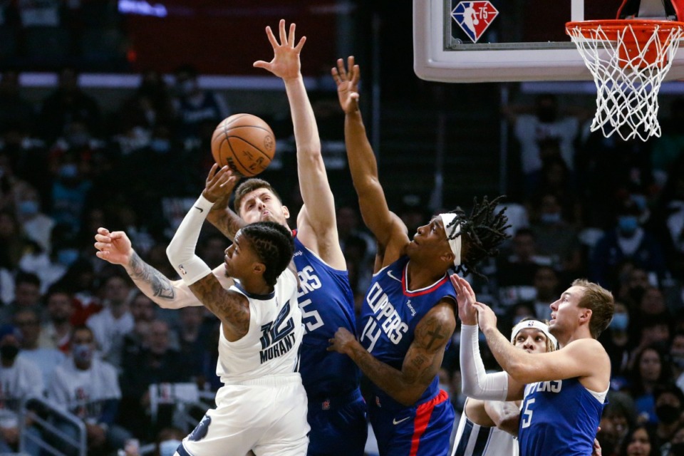 <strong>Memphis Grizzlies guard Ja Morant (12) looks to pass the ball while defended by Los Angeles Clippers center Isaiah Hartenstein (55) and guards Terance Mann (14) and Luke Kennard (5) during the first half of an NBA basketball game Saturday, Oct. 23, 2021, in Los Angeles.</strong> (AP Photo/Ringo H.W. Chiu)