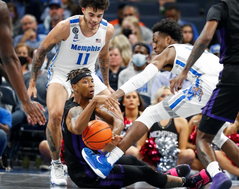 <strong>Tigers teammates Lester Quinones (left) and DeAndre Williams (right) battle LeMoyne-Owen College forward Jaquan Lawrence (middle) for a loose ball&nbsp; Sunday, Oct. 24, 2021 at FedExForum.</strong> (Mark Weber/The Daily Memphian)