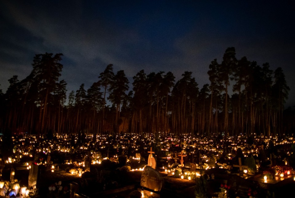 <strong>Relatives gather around some of the graves illuminated by candles during All Saints Day at a cemetery in Vilnius, Lithuania, Sunday, Nov. 1, 2020. Candles illuminated tombstones in graveyards across Europe as people communed with the souls of the dead on Thursday, observing one of the most sacred days in the Catholic calendar.</strong> (AP Photo/Mindaugas Kulbis)