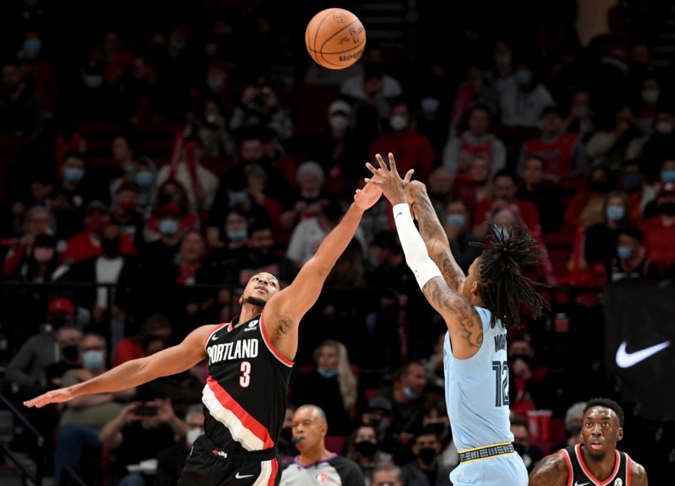 <strong>Grizzlies guard Ja Morant, right, shoots the ball over Trail Blazers guard CJ McCollum, left,&nbsp;on Oct. 27 in Portland.</strong> (Steve Dykes/AP)
