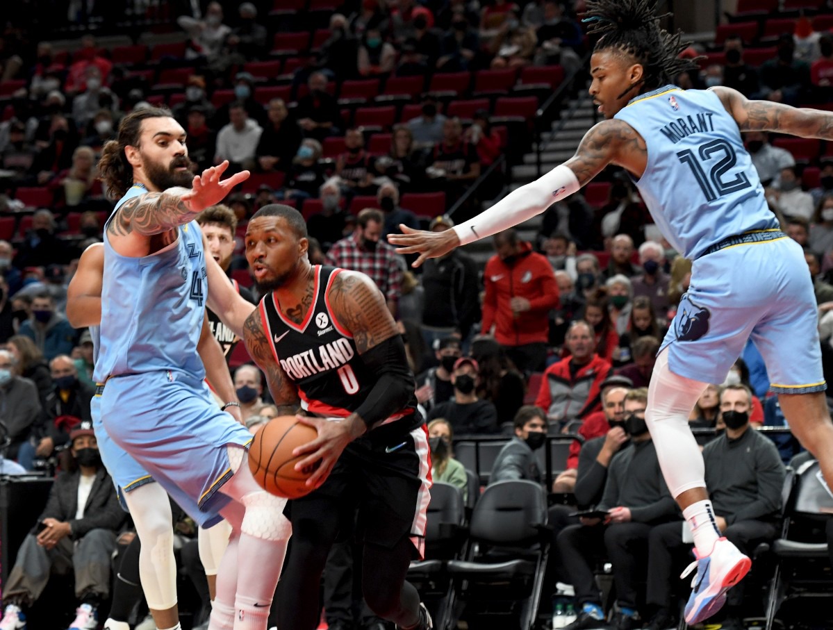 <strong>Trail Blazers guard Damian Lillard, center, drives to the basket against Grizzlies center Steven Adams, left,&nbsp;on Oct. 27 in Portland.</strong> (Steve Dykes/AP)