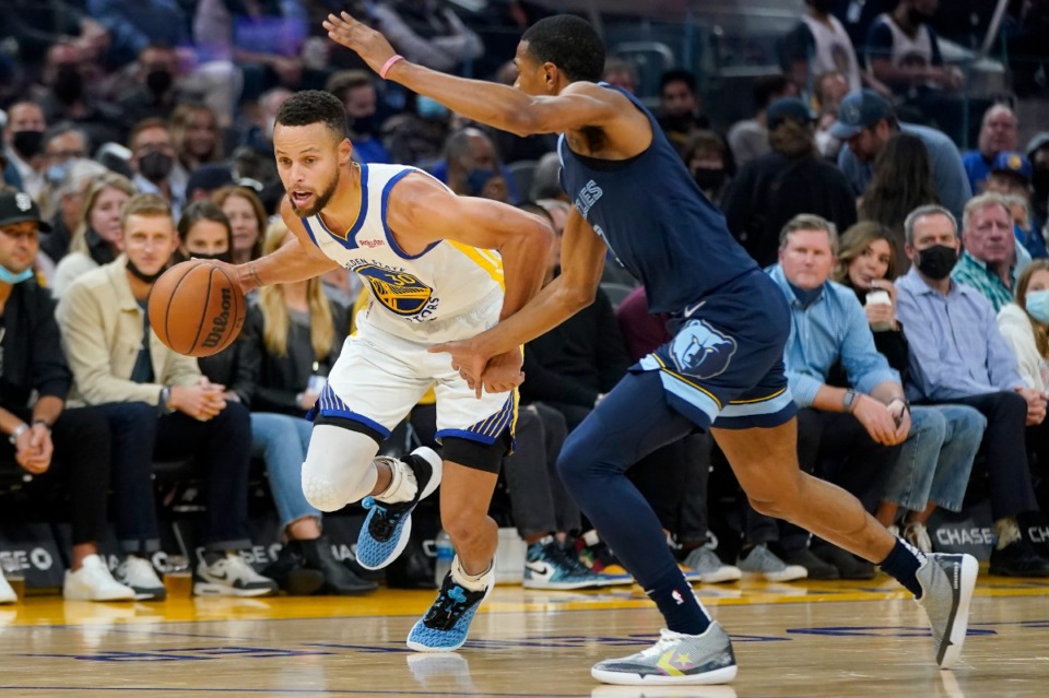 <strong>Golden State Warriors guard Stephen Curry, left, drives against Grizzlies guard De'Anthony Melton on Oct. 28 in San Francisco.</strong> (Jeff Chiu/AP)