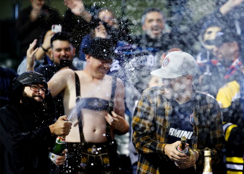 <strong>Memphis 901 FC fans break out the champagne after the team's last regular season match, Oct. 30, 2021, against Indy Eleven.</strong> (Patrick Lantrip/Daily Memphian)