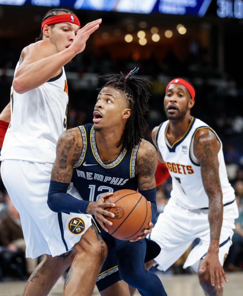 <strong>Grizzlies guard Ja Morant drives the lane against Denver Nuggets defenders Aaron Gordon (left) and Will Barton on Wednesday, Nov. 3.</strong> (Mark Weber/Daily Memphian)