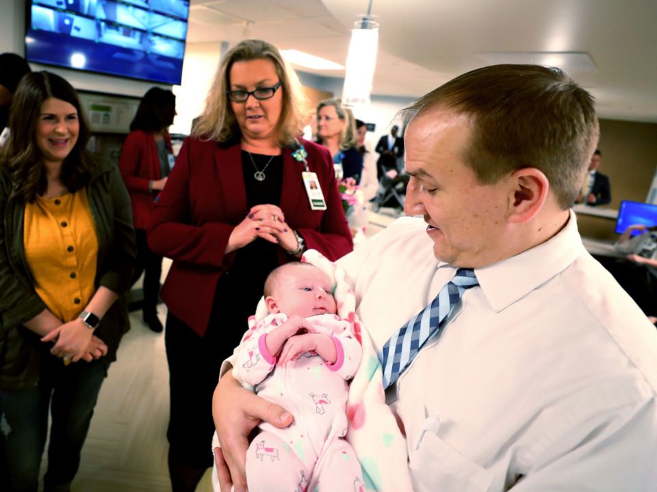 <strong>Dr. Michael Podraza (right) holds one month old Anna Marie Jacob&nbsp; during a ribbon-cutting ceremony for the new family birthing center in Saint Francis Hospital. The center features new two-room suites that provide a comfortable environment for the entire family.</strong> (Houston Cofield/Daily Memphian)