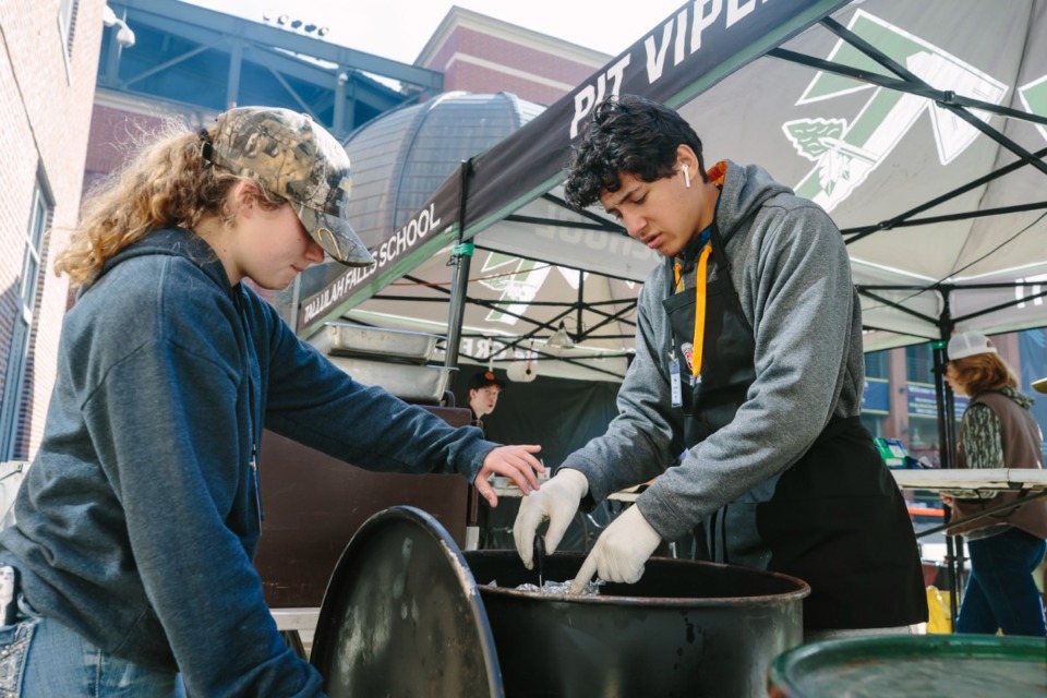 <strong>Tallulah Falls (Ga.) High School students Brooke Hayes (left) and Marc Crotta test the temperature of meat during the&nbsp;World Junior Barbecue League Championship, Saturday, Nov. 6, 2021 at AutoZone Park. Their team, Pit Vipers B, won the grand championship prize.</strong> (Ziggy Mack/Special to The Daily Memphian)