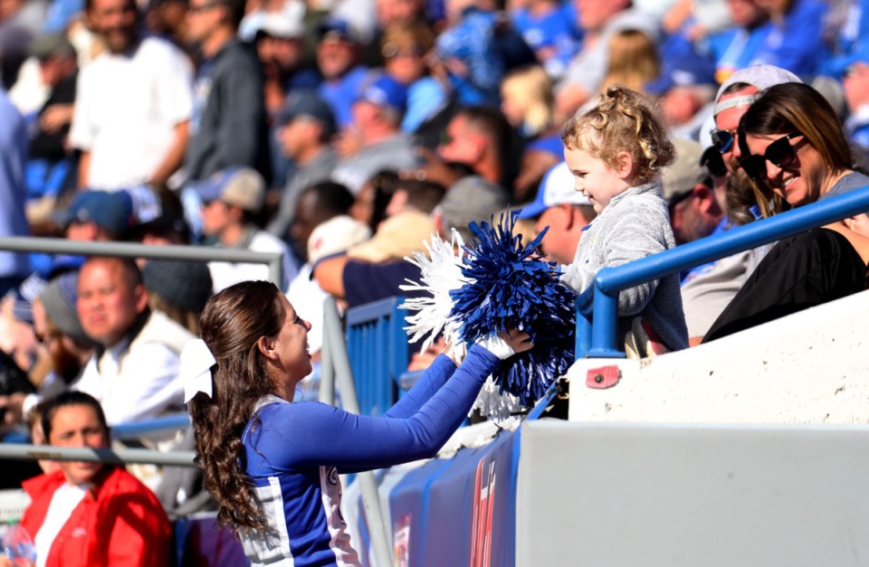 <strong>A University of Memphis cheerleader lets a young fan try out her pom poms during a Nov. 6, 2021 home game against SMU.</strong> (Patrick Lantrip/Daily Memphian)