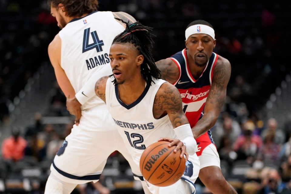 <strong>Memphis Grizzlies guard Ja Morant (12) drives past Washington Wizards guard Kentavious Caldwell-Pope, right, as Caldwell-Pope is screened by Grizzlies center Steven Adams, of New Zealand, in the first half of an NBA basketball game, Friday, Nov. 5, 2021, in Washington.</strong> (AP Photo/Patrick Semansky)