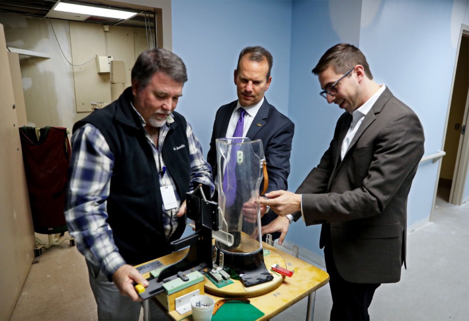 <strong>Braden Health&rsquo;s Kyle Kopec (right) and Terry Stewart (left) show Haywood County Community Hospital CEO Michael Banks a &ldquo;Pigg-O-Stat&rdquo; machine they found while renovating the hospital. The&nbsp; machines were used to immobilize infants and young children before widespread use of anesthesia. It was still in use when the hospital closed its doors in 2014.</strong> (Patrick Lantrip/Daily Memphian)