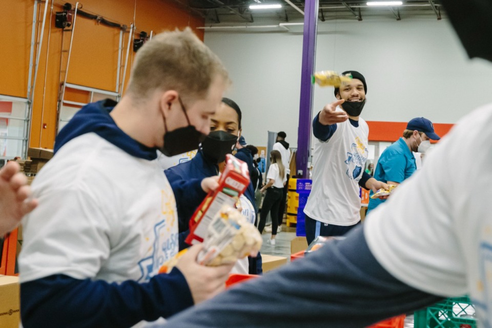 <strong>Dillon Brooks passing goods to Memphis Grizzlies teammates and staff while volunteering at Mid-South Food Bank on November 17, 2021.</strong> (Ziggy Mack/Special to The Daily Memphian)