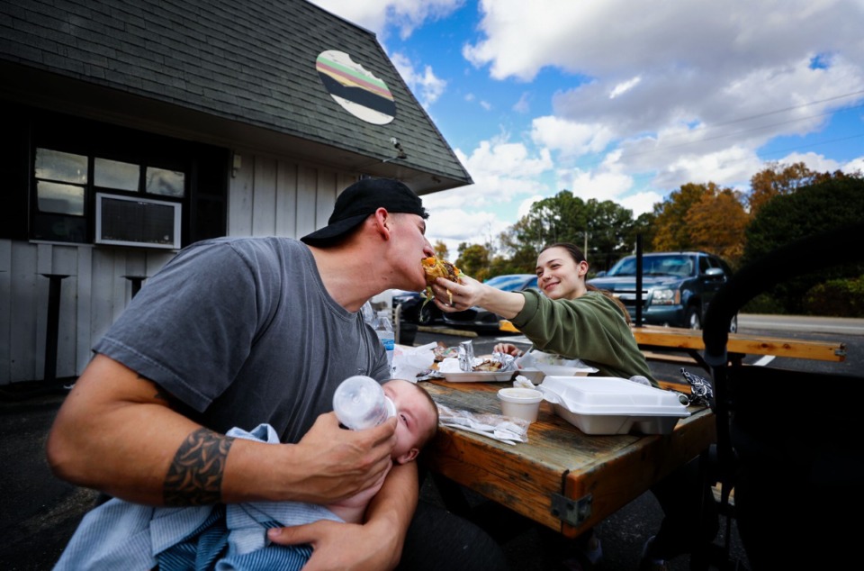 <strong>Damian and Beth Gonzalez share a bite to eat while stopping by Sidestreet Burgers in Olive Branch, Mississippi while traveling from Florida to Colorado with their baby Bentley on Nov. 17, 2021.</strong> (Patrick Lantrip/Daily Memphian)