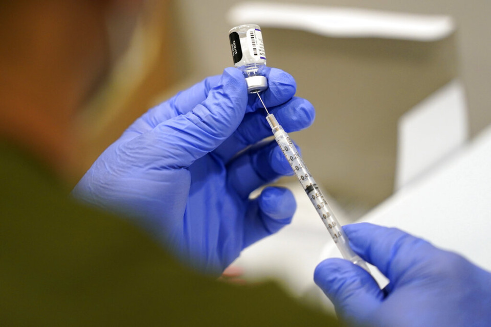 <strong>A healthcare worker fills a syringe with the Pfizer COVID-19 vaccine at Jackson Memorial Hospital on Oct. 5, 2021, in Miami. U.S. regulators have opened up COVID-19 booster shots to all and more adults, Friday, Nov. 19, letting them choose another dose of either the Pfizer or Moderna vaccine.</strong> (AP Photo/Lynne Sladky, File)