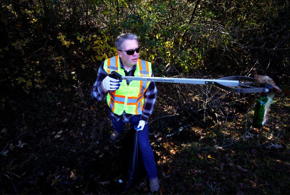 <strong>Collierville chief of police Dale Lane helps pick up trash, including part of an office chair, from the side of the road on Friday, Nov. 19.</strong> (Patrick Lantrip/Daily Memphian)