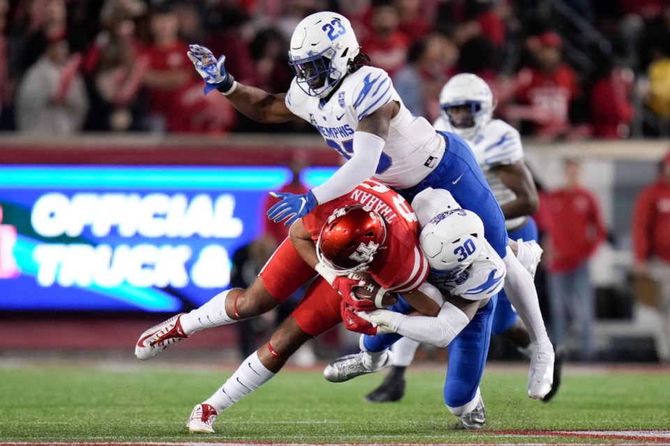<strong>Houston tight end Christian Trahan, bottom left, is tackled by Memphis defensive back Rodney Owens (30) and JJ Russell (23) on Friday, Nov. 19, 2021, in Houston.</strong> (Eric Christian Smith/AP)