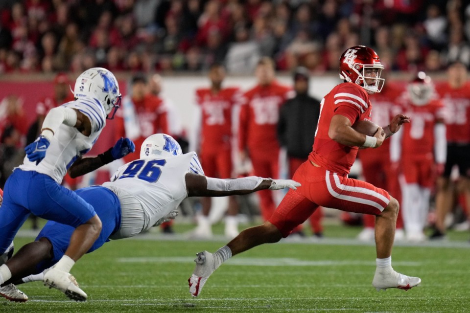 <strong>Houston quarterback Clayton Tune, right, escapes a tackle by Memphis defensive lineman Zy Brockington (96)</strong>&nbsp;<strong>on Friday, Nov. 19, 2021, in Houston.</strong> (Eric Christian Smith/AP)