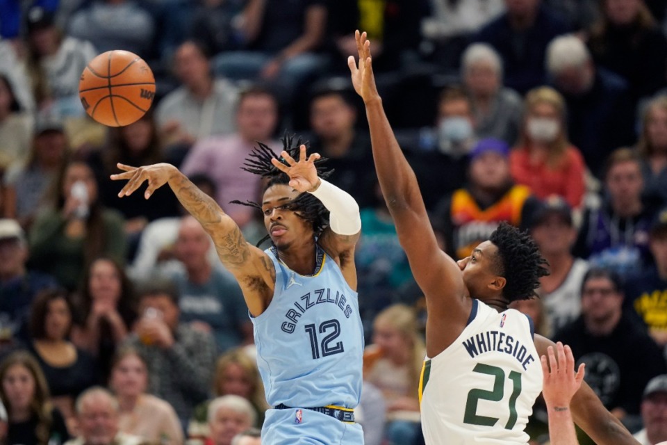 <strong>Memphis Grizzlies guard Ja Morant (12) passes the ball as Utah Jazz center Hassan Whiteside (21) defends during the first half of an NBA basketball game Monday, Nov. 22, 2021, in Salt Lake City.</strong> (AP Photo/Rick Bowmer)