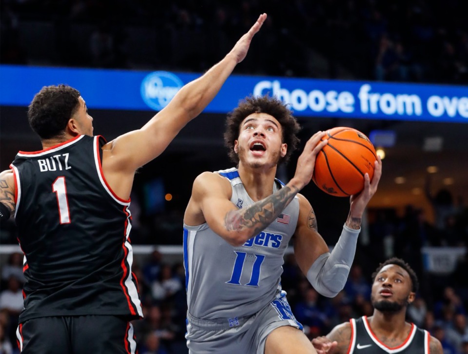 <strong>Memphis Tigers guard Lester Quinones (11) drives to the basket against Western Kentucky University defender Jaylen Butz (left) during action on Friday, Nov. 19, 2021.</strong> (Mark Weber/The Daily Memphian)