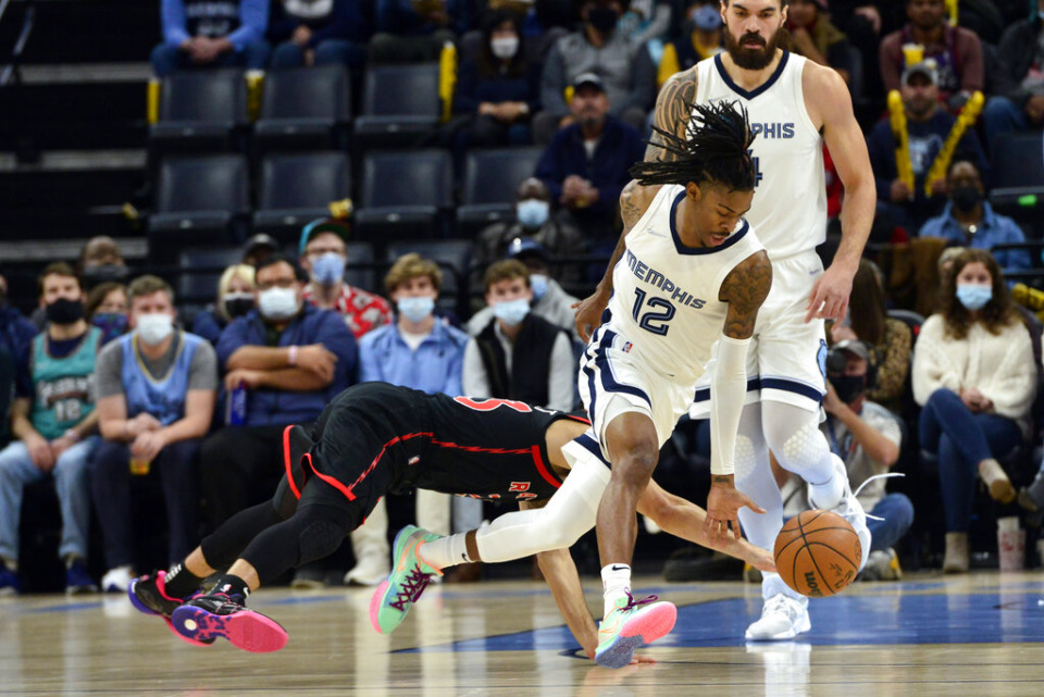 <strong>Memphis Grizzlies guard Ja Morant (12) and Toronto Raptors guard Fred VanVleet (23) reach for a loose ball in the first half of an NBA basketball game Wednesday, Nov. 24, 2021, in Memphis.</strong> (AP Photo/Brandon Dill)