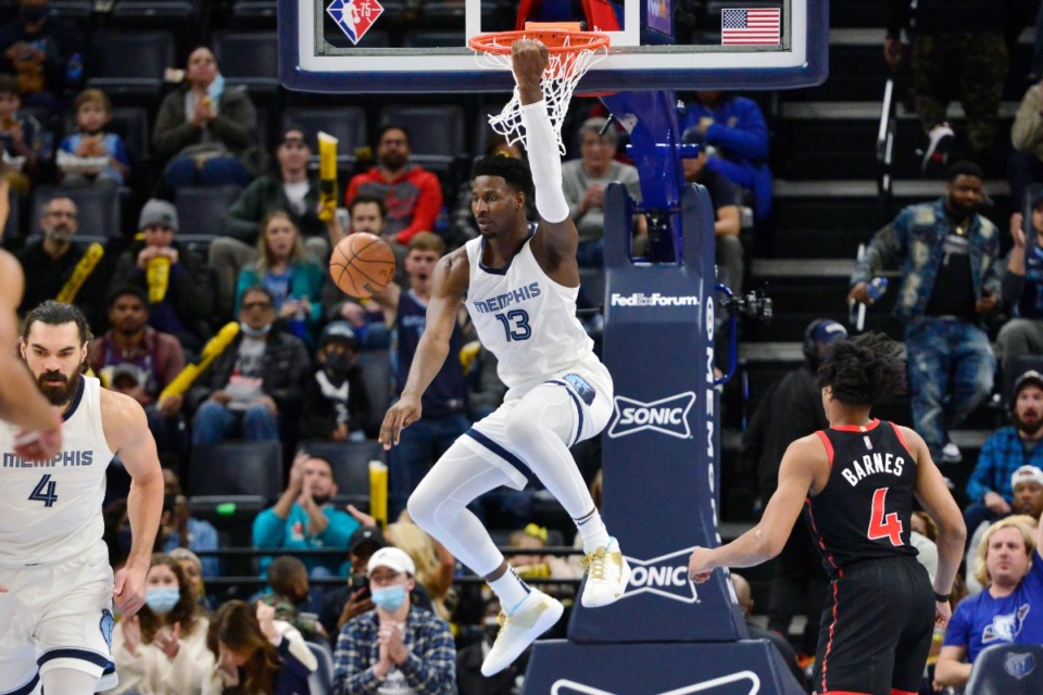 <strong>Memphis Grizzlies forward Jaren Jackson Jr. (13) hangs from the rim after dunking the ball in the first half of an NBA basketball game against the Toronto Raptors Wednesday, Nov. 24, 2021, in Memphis, Tennessee.</strong> (AP Photo/Brandon Dill)