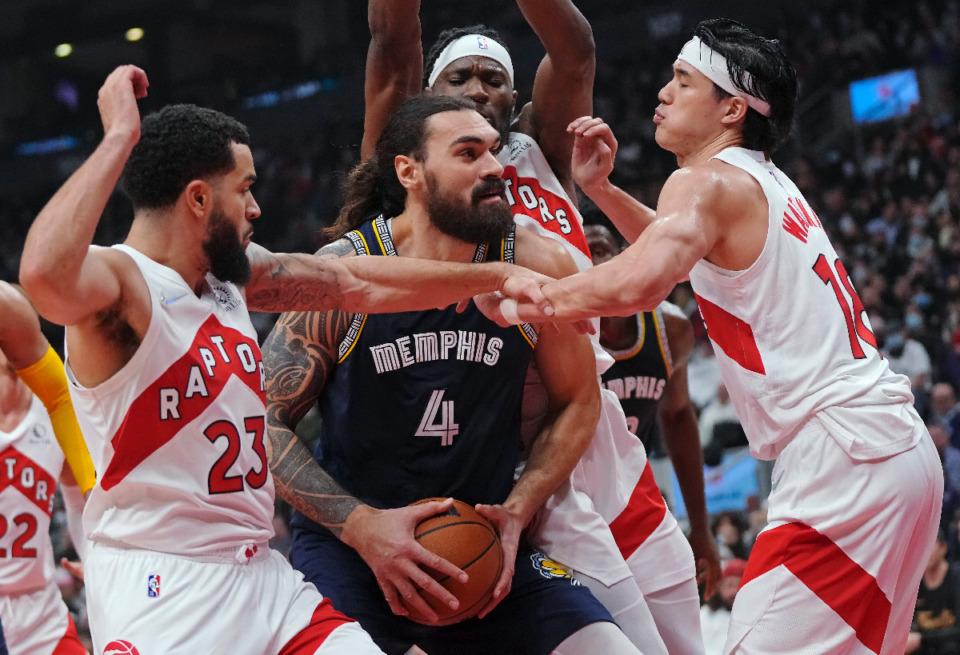 <strong>Memphis Grizzlies center Steven Adams (4) protects the ball from Toronto Raptors guard Fred VanVleet (23) and forward Yuta Watanabe (18) during the first half of an NBA basketball game Tuesday, Nov. 30, 2021, in Toronto.</strong> (Nathan Denette/The Canadian Press via AP)