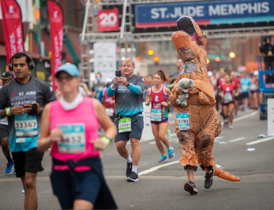 <strong>Rory Green runs the St. Jude Memphis Marathon in an unconventional way, in a dinosaur costume Saturday, Dec. 4, 2021.</strong> (Greg Campbell/Special to The Daily Memphian)