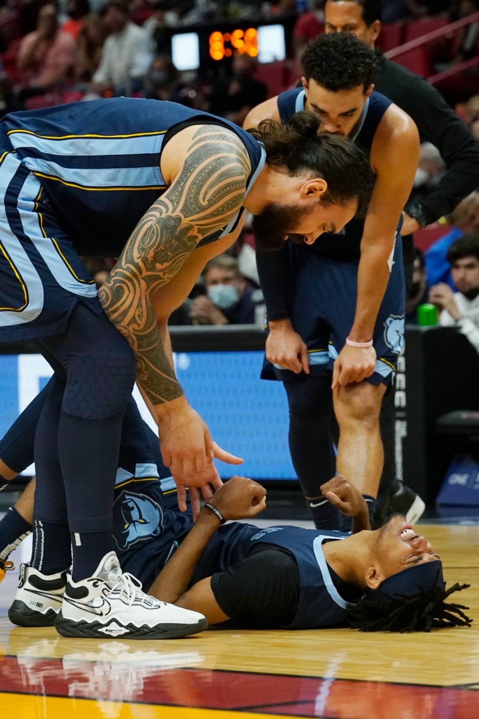 <strong>Grizzlies guard Ziaire Williams (on floor) is assisted by center Steven Adams, left, and guard Tyus Jones after he was injured in the game against the Miami Heat</strong>&nbsp;<strong>on Dec. 6, 2021, in Miami.</strong> (Marta Lavandier/AP)