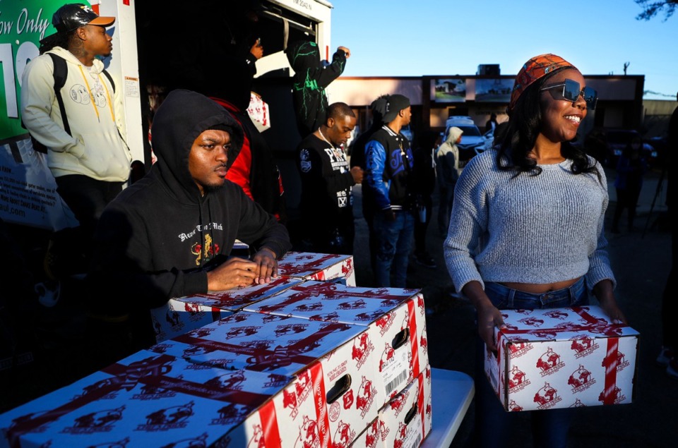 <strong>Gerica Robertson (right) helps pass out turkeys at St. James Missionary Baptist Church in South Memphis Nov. 19. The event was planned by local rapper Young Dolph before he was killed. The City Council passed a resolution honoring the rapper by renaming a street.</strong> (Patrick Lantrip/Daily Memphian)