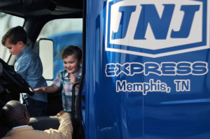 <strong>Grayson and Easton Ennis, the sons of JNJ Express CEO John Ennis Jr., play in the cab of one of their father&rsquo;s trucks under the watchful eye of longtime employee Lester Lawson on Tuesday, Feb. 26.&nbsp;The transportation company, which was founded in Memphis 27 years ago, is moving its headquarters, operations center, vehicle maintenance facility and cross dock to a vacant Parkway Village shopping center.</strong> (Patrick Lantrip/Daily Memphian)