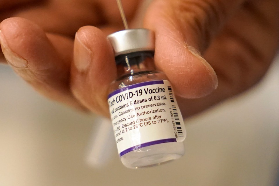 <strong>Dr. Manjul Shukla transfers Pfizer COVID-19 vaccine into a syringe, Thursday, Dec. 2, 2021, at a mobile vaccination clinic in Worcester, Massachusetts. Pfizer said Wednesday, Dec. 8, 2021, that a booster dose of its COVID-19 vaccine may protect against the new omicron variant even though the initial two doses appear significantly less effective.</strong> (AP Photo/Steven Senne, File)