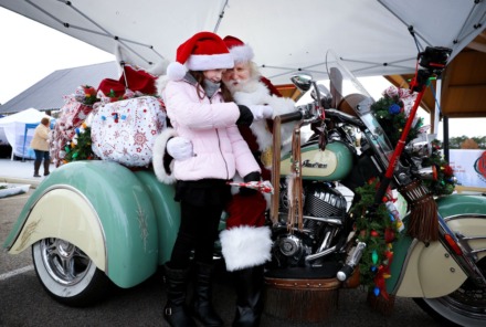 <strong>Motorcycle Santa Billy Power gives Avery Roberts a gift at Freeman Park in Bartlett, Dec. 11, 2021.</strong> (Patrick Lantrip/The Daily Memphian)