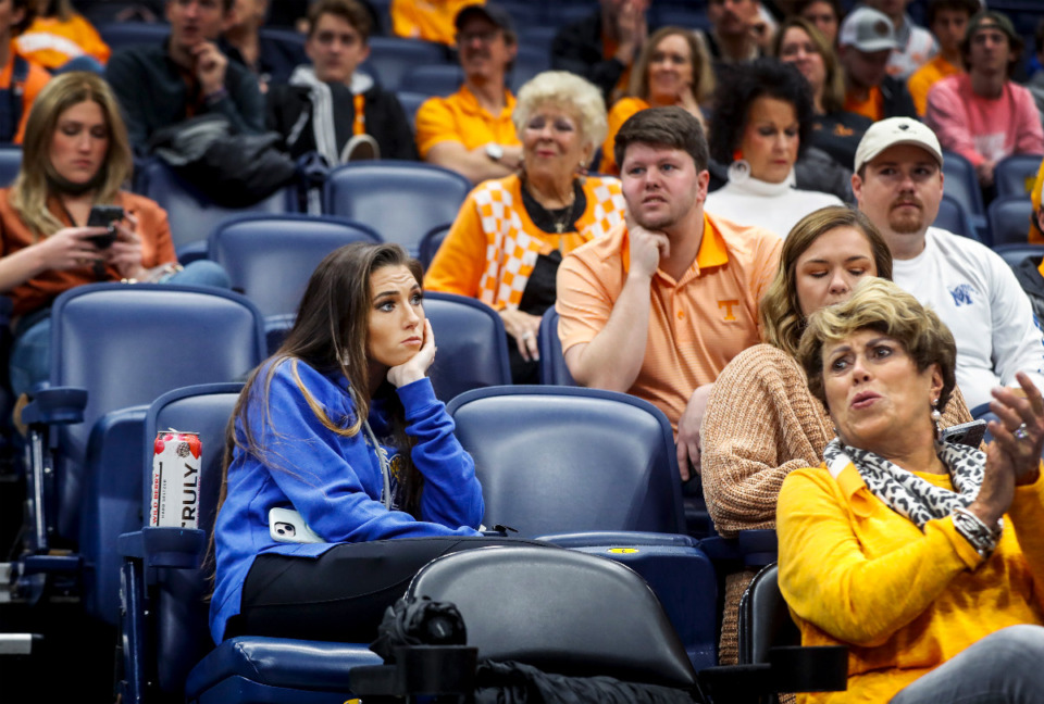 <strong>Memphis fan Katie Hart (middle) sits in the stands with Tennessee fans as the Vols basketball team scrimmages, after a positive COVID test on the Tigers team canceled their game against Tennessee on Saturday, Dec. 18, 2021 in Nashville.</strong> (Mark Weber/The Daily Memphian)