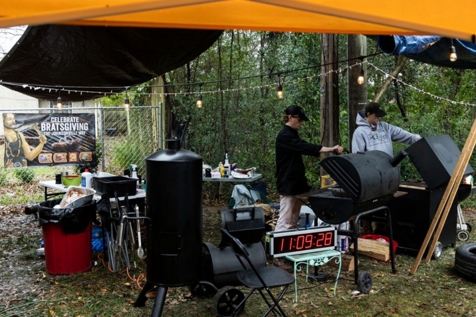 <strong>Addison Fordick, left, and Robert Hammons, right, check their food while attempting to break a Guinness World Record for longest team barbecue.</strong> (Brad Vest/Special to The Daily Memphian)&nbsp;