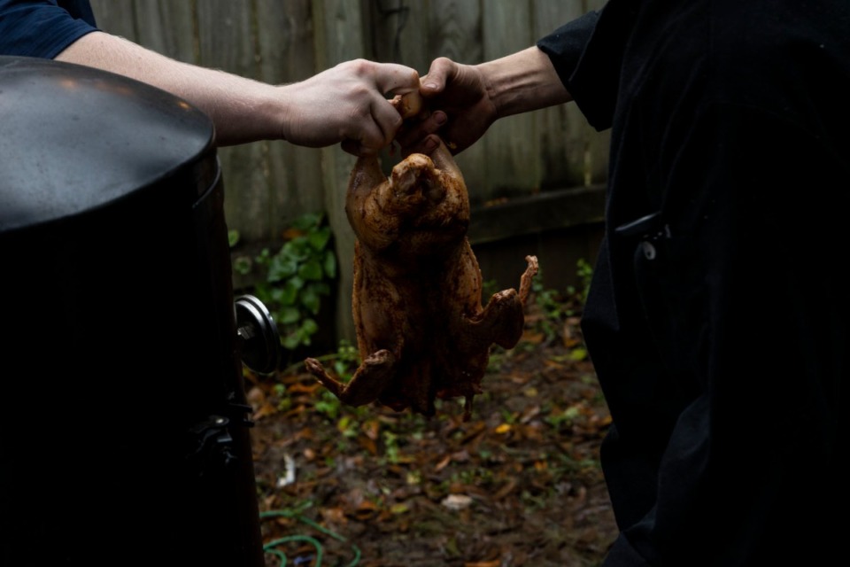 <strong>A duck is handed off before going into a smoker during an attempt to break a Guinness World Record for longest team barbecue.</strong> (Brad Vest/Special to The Daily Memphian)&nbsp;