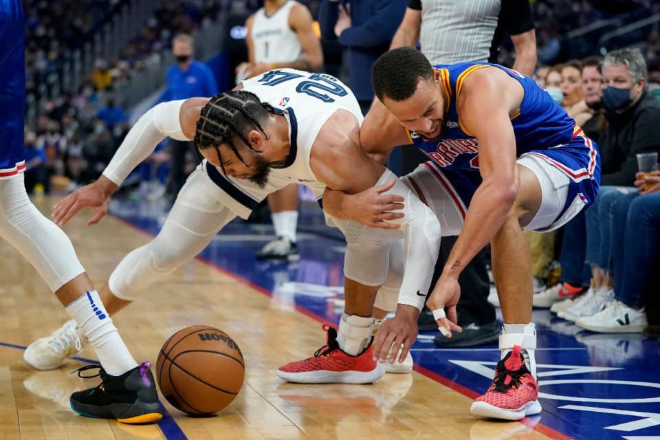 <strong>Memphis Grizzlies forward Dillon Brooks, left, gets tangled up with Golden State Warriors guard Stephen Curry on Dec. 23, 2021.</strong> (Jeff Chiu/AP file)