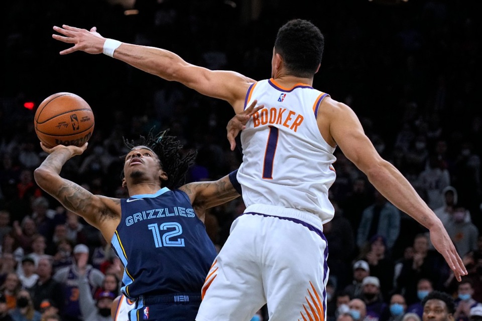 <strong>Grizzlies guard Ja Morant scores against Phoenix Suns guard Devin Booker (1) in the last second of the game Dec. 27, giving Memphis a 114-113 win.</strong> (Rick Scuteri/AP)