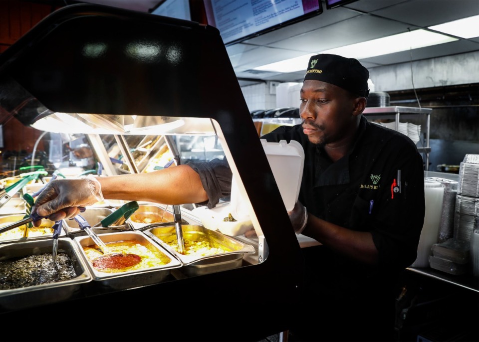 <strong>Bala's Bistro owner Bala Tounkara makes a buffett plate. The restaurant&rsquo;s fish attieke&nbsp;was one of Jennifer Biggs&rsquo; 10 best dishes of 2021.</strong> (Mark Weber/The Daily Memphian file)