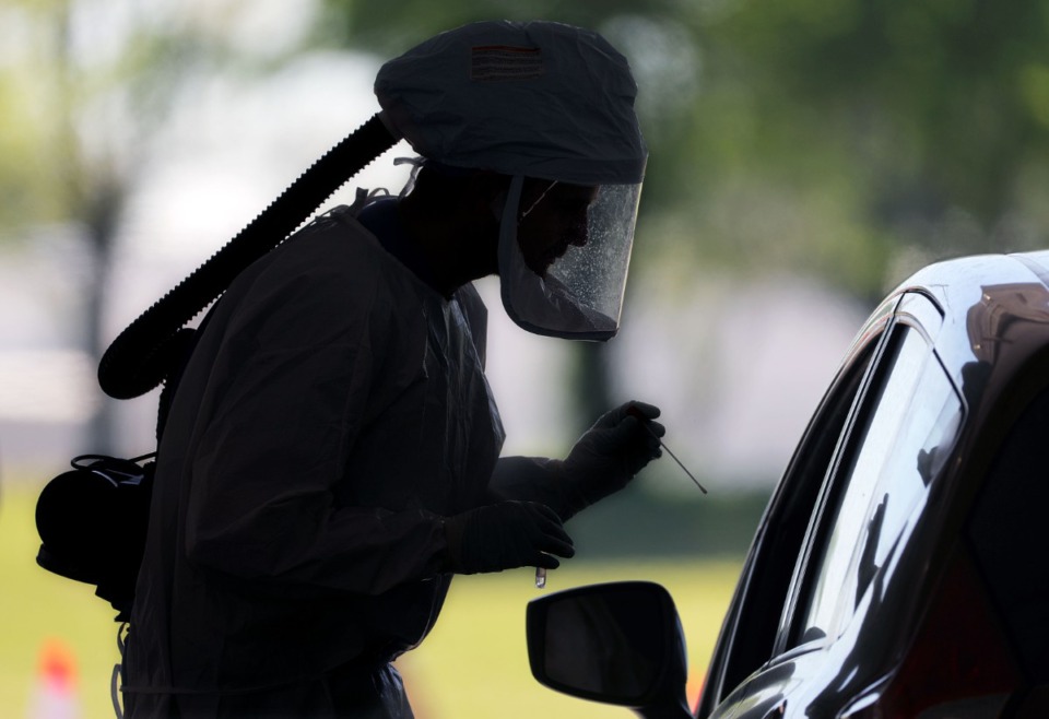 <strong>A worker prepares to test a patient for COVID-19 at the drive-thru testing facility in April 2020.</strong> (Patrick Lantrip/Daily Memphian file)