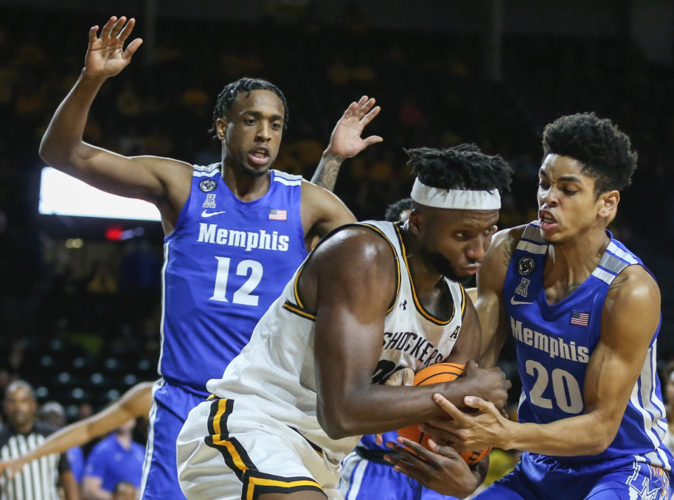 <strong>DeAndre Williams (12) and Josh Minott (20) battle a Wichita State Shocker for the ball on Jan. 1, 2022.</strong> (Travis Heying/Wichita Eagle)